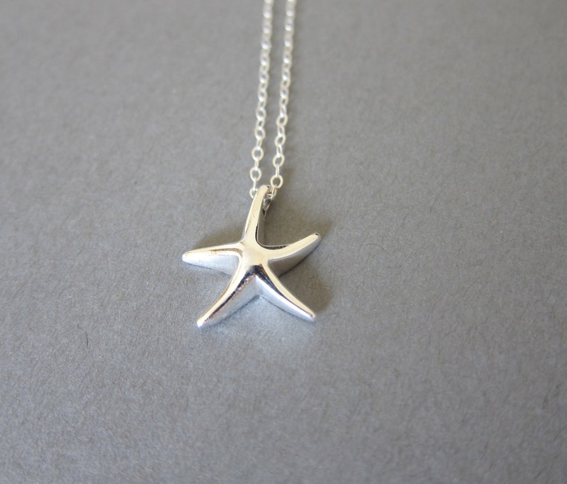 May include: A silver necklace with a starfish pendant. The starfish is a simple design with five points.