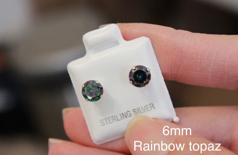 Puede incluir: Un par de pendientes de bot&oacute;n de plata de ley con piedras preciosas de topacio arco&iacute;ris de 6 mm. Los pendientes est&aacute;n en una tarjeta blanca con el texto "Sterling Silver" y "6mm Rainbow Topaz".