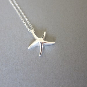 May include: A silver chain necklace with a silver starfish pendant.