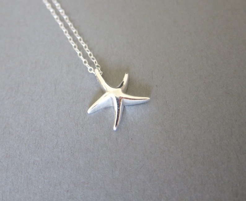 May include: A silver chain necklace with a silver starfish pendant.