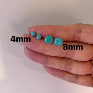 May include: A collection of turquoise stud earrings in various sizes. The earrings are round with a silver setting. The image shows earrings in 4mm and 8mm sizes. The turquoise stones have a marbled appearance.
