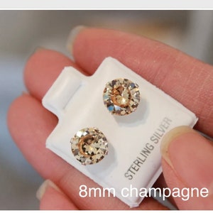 Puede incluir: Un par de pendientes de bot&oacute;n de color champ&aacute;n de 8 mm en una tarjeta blanca con el texto "Sterling Silver".