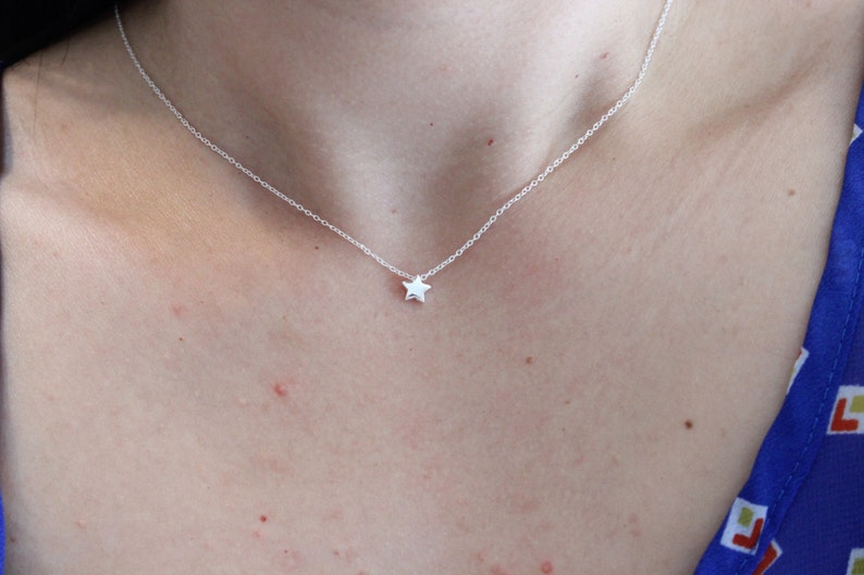 May include: A silver chain necklace with a small star pendant.