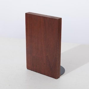 May include: A wooden bookend with a dark brown finish and a black metal base.
