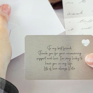 May include: A silver metal card with a heart-shaped cutout and an engraved message that reads: "To my best friend. Thank you for your unwavering support and love. I'm very lucky to have you in my life. Lots of love always Katie"