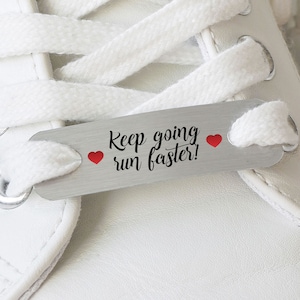 May include: A silver shoe charm with the text "Keep going run faster!" and two red hearts.