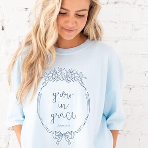 girl wearing a chambray comfort colors t-shirt with custom grow in grace floral frame printed design