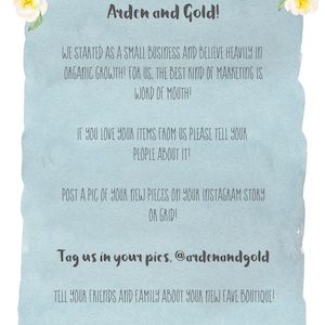 Peut inclure: Une carte de remerciement bleue et blanche avec des accents floraux. La carte encourage les clients &agrave; partager leurs achats sur les r&eacute;seaux sociaux et &agrave; taguer l'entreprise @ardenandgold. Elle inclut &eacute;galement l'adresse du site Web de l'entreprise : ardenandgold.com.