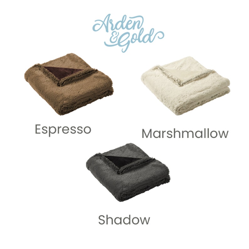 Pu&ograve; includere: Tre coperte di peluche piegate in Espresso, Marshmallow e Shadow. Ogni coperta ha un bordo a contrasto. Il logo Arden & Gold &egrave; in alto a destra.