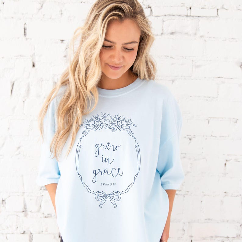 girl wearing a chambray comfort colors t-shirt with custom grow in grace floral frame printed design