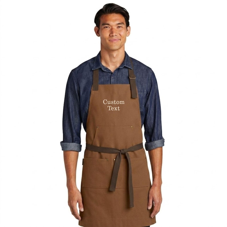 man wearing duck brown apron with custom text embroidery