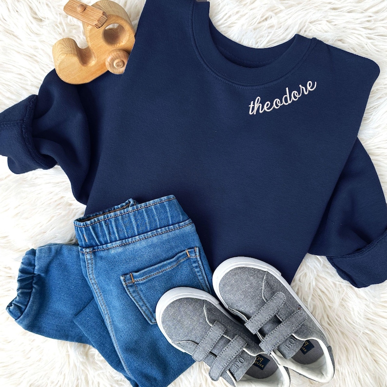 toddler navy crewneck sweatshirt with embroidered name along the collar