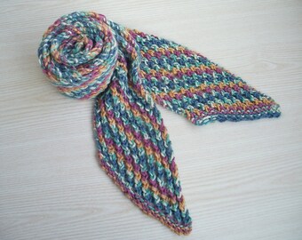 Könnte beinhalten: Handgestrickter Schal in Blau-, Türkis-, Lila- und Pfirsichtönen. Der Schal ist an einem Ende zusammengerollt und hat ein strukturiertes Rippenmuster. Die Enden sind spitz. Der Schal ist aus weichem Garn gefertigt.