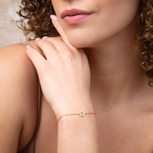 May include: A rose gold chain bracelet with a delicate Star of David charm.