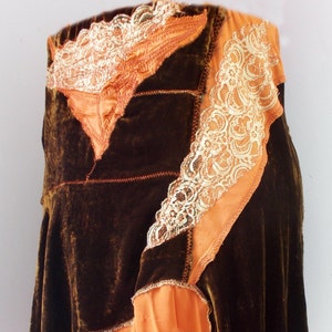 Può includere: Una gonna di velluto marrone con un volant di chiffon arancione a strati e un bordo in pizzo. La gonna ha un design asimmetrico unico.