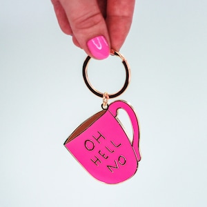 May include: Pink metal keychain shaped like a coffee mug with the text "Oh Hell No" in black lettering.
