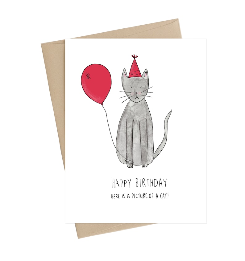 May include: A birthday card with a gray cat wearing a red party hat and holding a red balloon. The card says "Happy Birthday" and "Here is a picture of a cat!"
