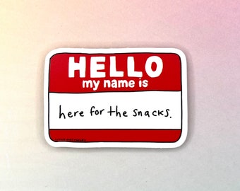 May include: A red and white name tag sticker with the text "HELLO my name is here for the snacks."