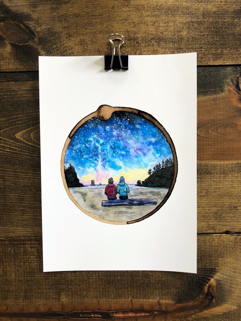 May include: Watercolor painting of two people sitting on a log, looking out at a beach scene with a starry sky above. The painting is framed in a circle, resembling a tree trunk.