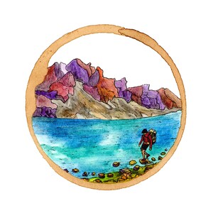 May include: Watercolor painting of a person walking on rocks towards a lake with mountains in the background. The painting is framed in a brown circle.