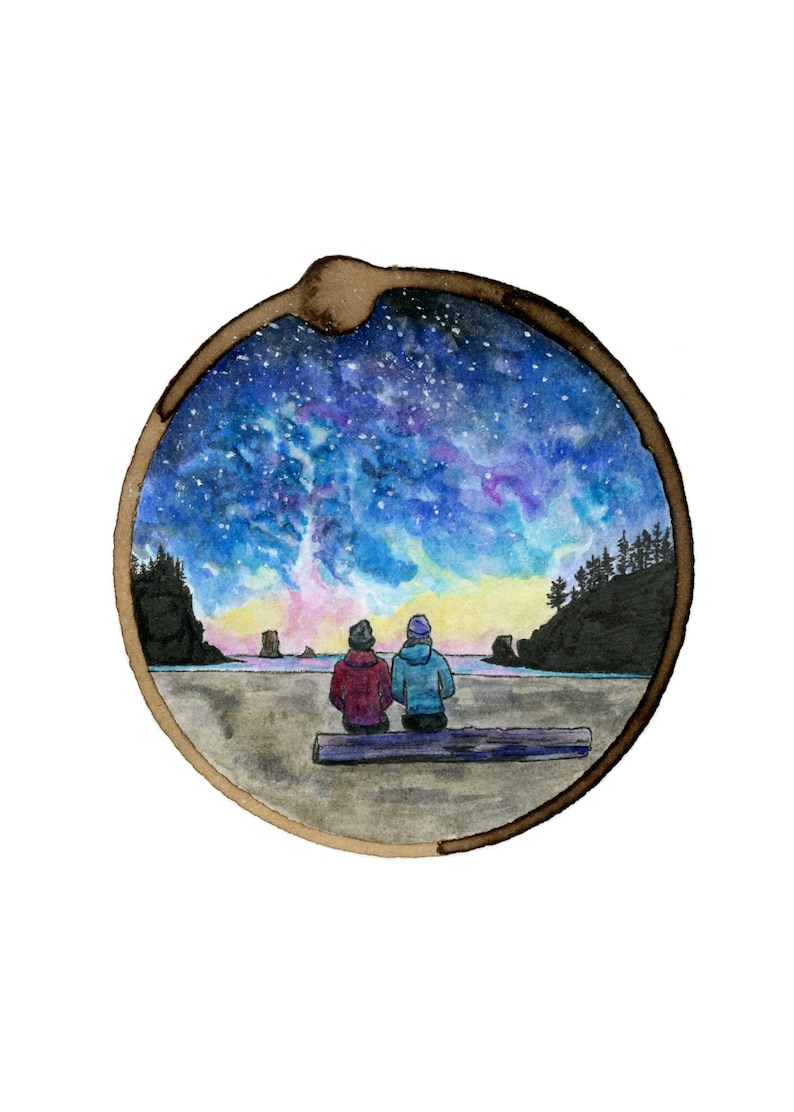 May include: A watercolor painting of two people sitting on a log, looking out at a beach scene with a starry sky and a colorful sunset. The painting is framed in a circle.