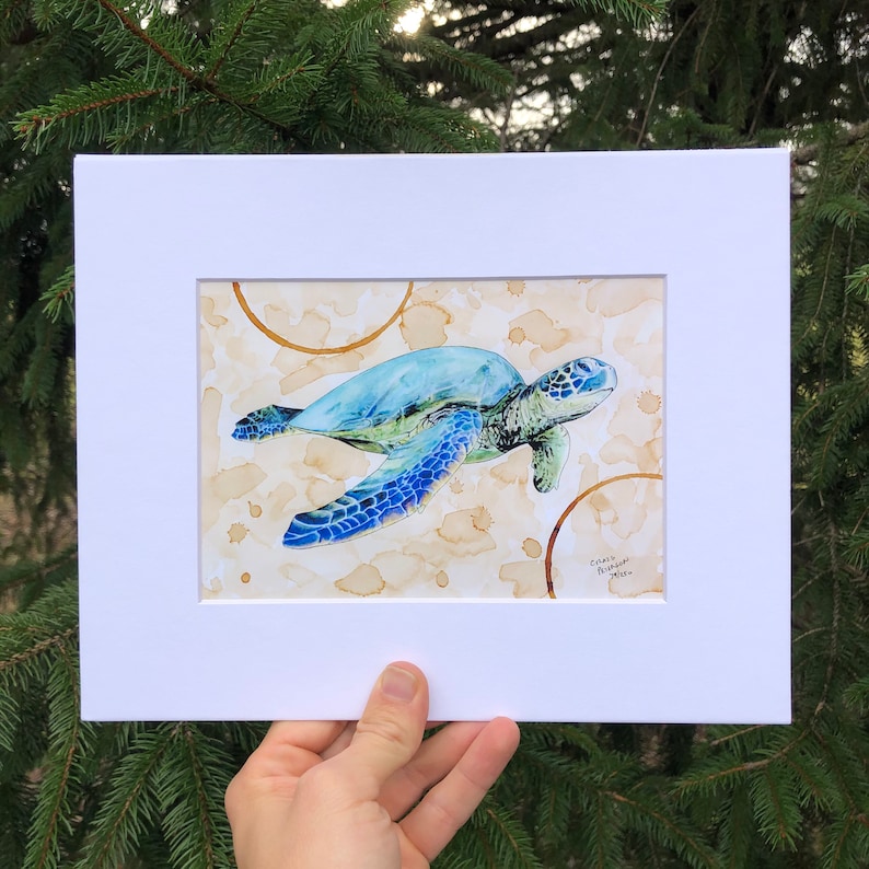 May include: A watercolor painting of a blue and green sea turtle swimming in a brown and white background with coffee stains. The artist's signature is in the bottom right corner.
