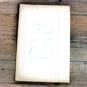 May include: A rectangular off-white paper ledger sheet featuring vertical red and blue ruled lines. The paper displays handwritten blue ink text that reads 1930, followed by a decorative flourish and the handwritten initials G. S. in blue ink.
