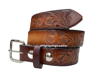 Könnte beinhalten: Ein brauner Ledergürtel mit Stern- und Blumenmuster. Der Gürtel hat eine silberne Schnalle und eine dunkelbraune Schlaufe. Das Leder ist mit einem Stern- und Rankenmuster geprägt. Der Gürtel ist etwa 3,8 cm breit.