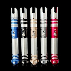 Puede incluir: Cinco empu&ntilde;aduras de sable l&aacute;ser en diferentes colores: azul, negro, dorado, gris y rojo. Cada empu&ntilde;adura tiene un dise&ntilde;o &uacute;nico y presenta un acabado met&aacute;lico plateado.
