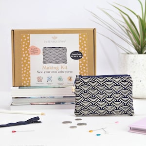 May include: A craft kit for making a coin purse, with a navy and cream wave design. The kit box displays the text "Making Kit" and "Sew your own coin purse." A completed purse, zipper, pins, and coins are also present.