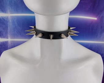 May include: A black leather choker with silver spikes. The choker is on a white mannequin.
