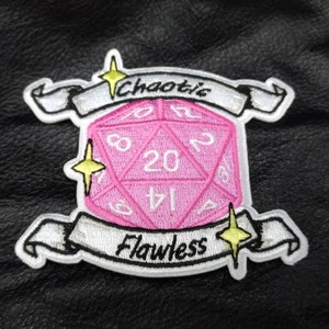 Peut inclure: Écusson brodé avec un dé à vingt faces rose, avec les mots "Chaotic" et "Flawless" sur des bannières. Bordure blanche et étoiles jaunes, parfait pour personnaliser vêtements et accessoires.