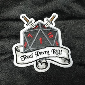 May include: A white embroidered patch with a black 20-sided die with red numbers, two crossed swords, and a white banner with the text "Total Party Kill!"