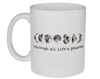 May include: White ceramic coffee mug with a black and white illustration of the moon in its different phases. The text "through all life's phases" is printed below the illustration.