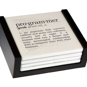May include: A set of four white coasters with a black wooden holder. The top coaster features a humorous definition of a programmer, which reads: "an organism that converts caffeine and pizza into software, usually late at night. A human that has a deeper and more meaningful relationship with a computer than with other humans."