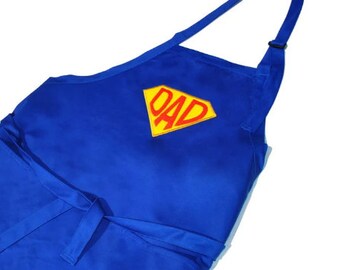 May include: Blue apron with a yellow and red superhero logo that says "DAD".