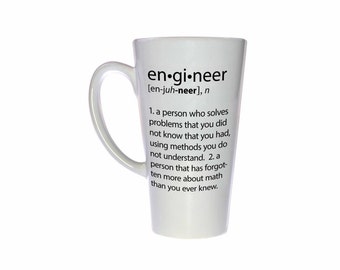 May include: White ceramic coffee mug with a black definition of the word "engineer" printed on the side. The definition reads: "[en-juh-neer], n 1. a person who solves problems that you did not know that you had, using methods you do not understand. 2. a person that has forgotten more about math than you ever knew."