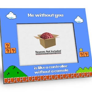 May include: A blue picture frame with a pixelated image of a brain in a box. The text "Me without you is like a controller without a console" is printed below the image. The frame has a pixelated border with a cloud, a star, and question marks.