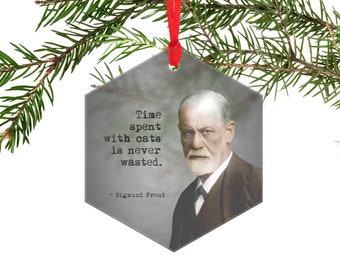 May include: A hexagonal gray Christmas ornament with a quote by Sigmund Freud: "Time spent with cats is never wasted." The ornament features a black and white photo of Sigmund Freud.