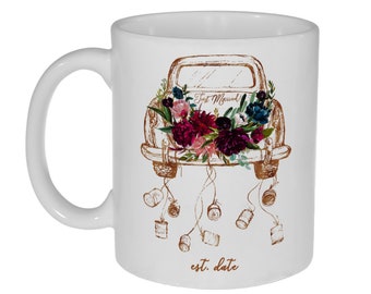May include: White ceramic mug with a gold outline of a vintage car with floral accents and the text "Just Married!" and "est. date".