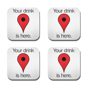 May include: Four white square coasters with a red and black location pin graphic and the text "Your drink is here."