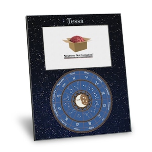 May include: A black picture frame with a blue background and a star pattern. The frame has a white mat and a clear picture window. The picture window shows a cartoon brain in a box with the text "Neurons Not Included". The bottom of the frame has a blue circle with a gold border and the zodiac signs. The text "Tessa" is at the top of the frame.