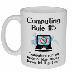 May include: White ceramic mug with a black and white image of a laptop with a red circle and slash through it. The text "Computing Rule #5" is above the image and the text "Computers run on magical blue smoke. Never let it get out." is below the image.