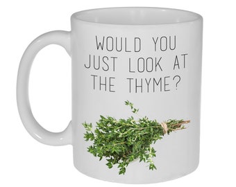 May include: White ceramic mug with a black text that reads "Would you just look at the thyme?" and a bunch of fresh thyme on the right side of the mug.