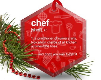 May include: Red glass ornament shaped like a hexagon with the word "chef" and a definition of the word. The ornament is decorated with kitchen-themed illustrations.