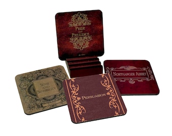 May include: Set of four square coasters featuring classic Jane Austen novel titles. Each coaster is made of a dark brown material with gold lettering and intricate designs. The titles include "Pride and Prejudice", "Sense and Sensibility", "Northanger Abbey", and "Persuasion".