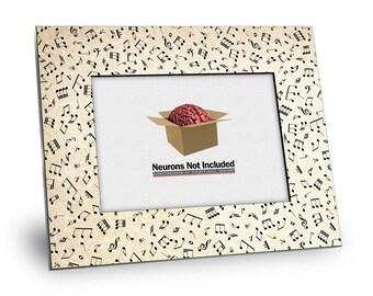May include: A black picture frame with a beige background and a pattern of black musical notes. The frame has a clear opening for a photo. The text "Neurons Not Included" is printed on the bottom of the frame.