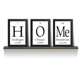 May include: Three black framed prints spelling out "HOME" using the chemical element symbols for Hydrogen, Oxygen, and Mendelevium. The atomic number and weight are listed below each element.