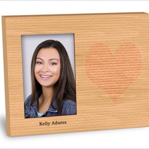 May include: A brown wooden picture frame with a digital pattern and a red heart shape made of binary code. The frame has a photo of a person with brown hair and a smile. The text "Kelly Adams" is printed below the photo.
