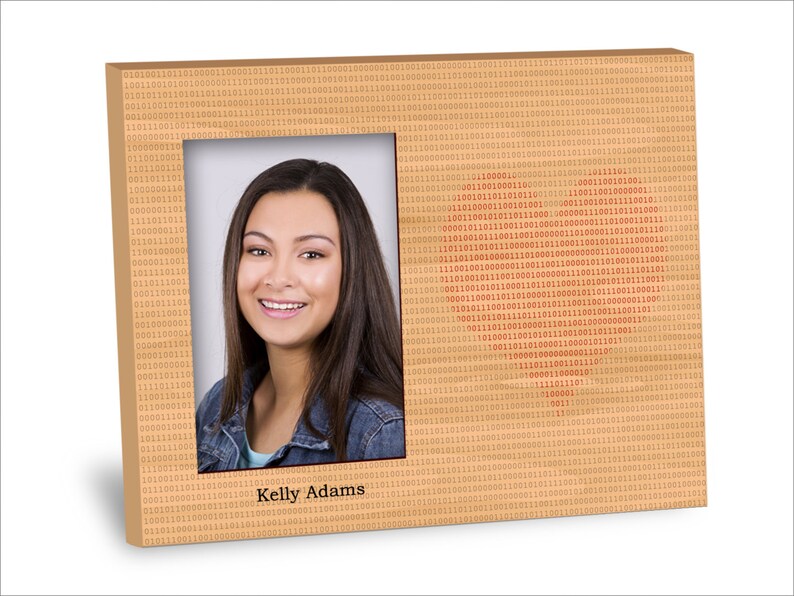 May include: A brown wooden picture frame with a digital pattern and a red heart shape made of binary code. The frame has a photo of a person with brown hair and a smile. The text "Kelly Adams" is printed below the photo.